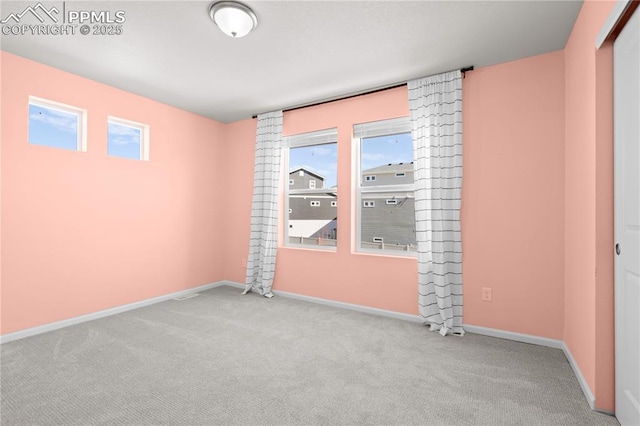 carpeted spare room featuring baseboards