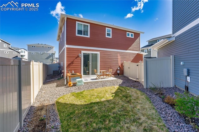 rear view of house with a yard, a patio, a fenced backyard, and central AC