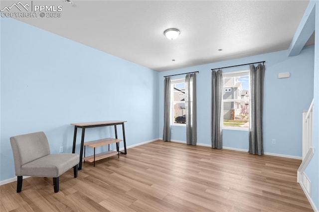 sitting room with light wood-style flooring and baseboards