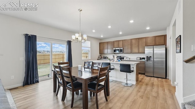6555 Roundtail Way, Colorado Springs, CO 80925 - dining area with an inviting chandelier, light wood-style floors, baseboards, and recessed lighting
