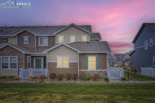 craftsman-style house with a shingled roof, stone siding, and a gate