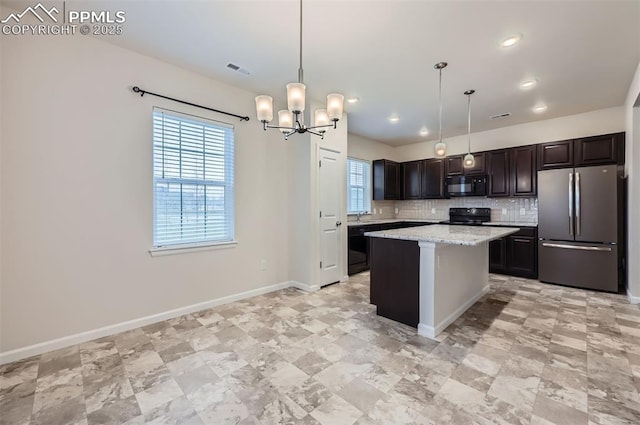 kitchen featuring black appliances, decorative backsplash, a chandelier, hanging light fixtures, and baseboards