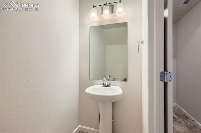 bathroom featuring baseboards and a sink