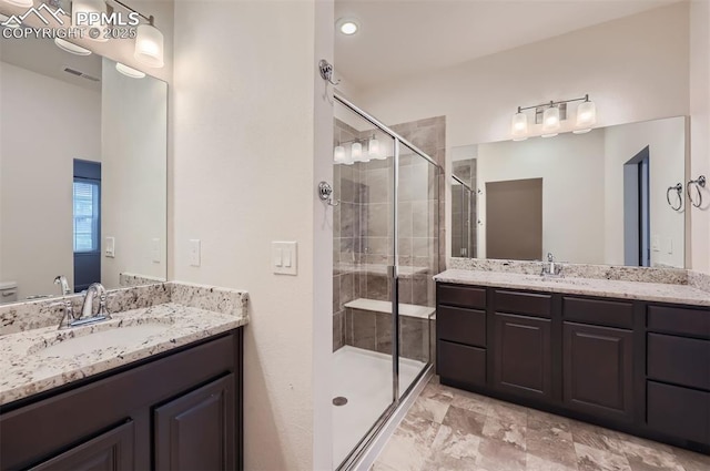 bathroom with a shower stall and two vanities