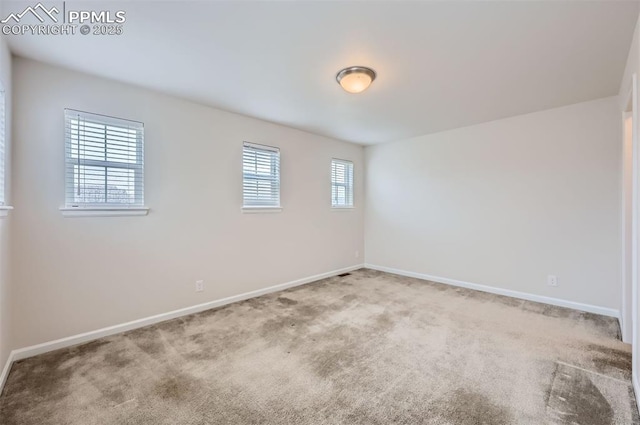 carpeted empty room with baseboards