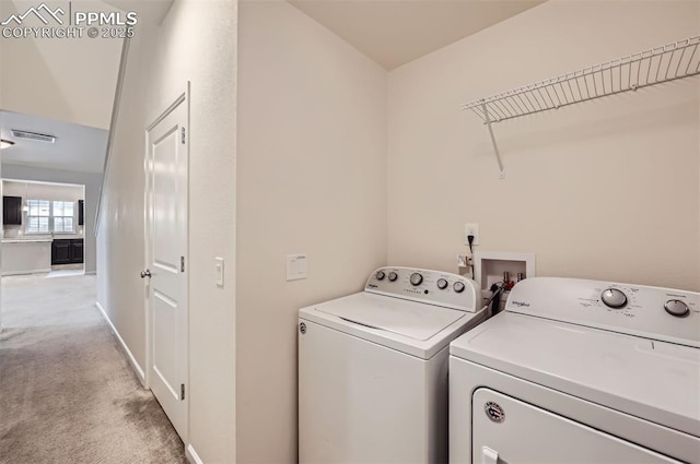 clothes washing area featuring separate washer and dryer, light colored carpet, and baseboards