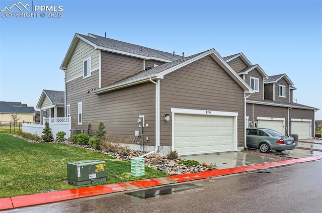 view of side of home featuring concrete driveway, a garage, and central AC