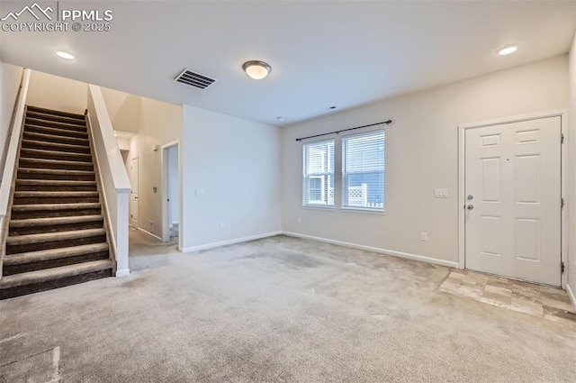 unfurnished living room featuring light carpet, stairway, and baseboards