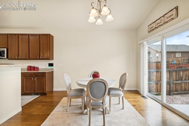 10842 Scenic Brush Dr, Peyton, CO 80831 - dining space featuring a chandelier, wood finished floors, and baseboards