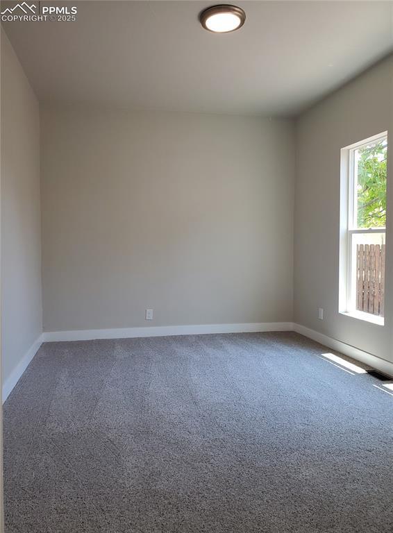 spare room featuring baseboards and carpet