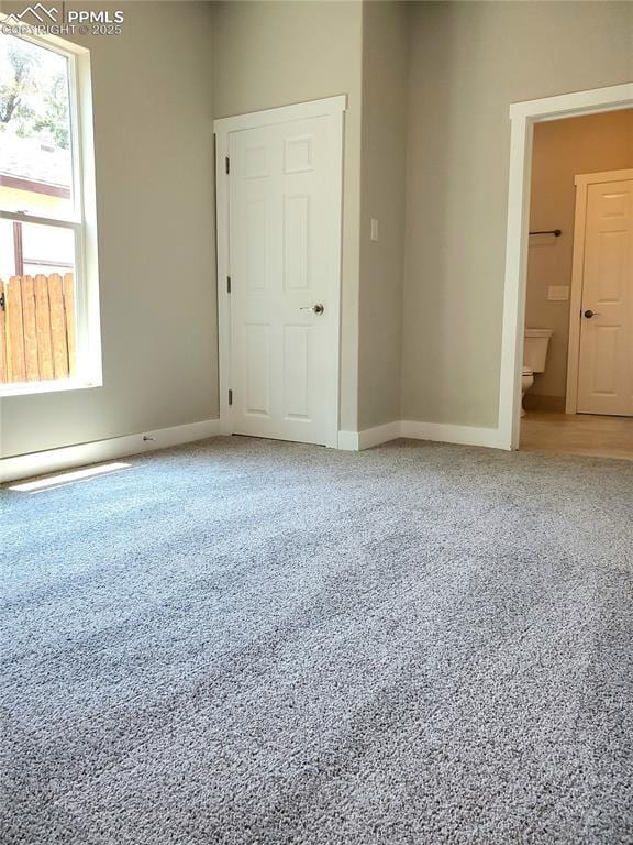 unfurnished room with baseboards and carpet flooring