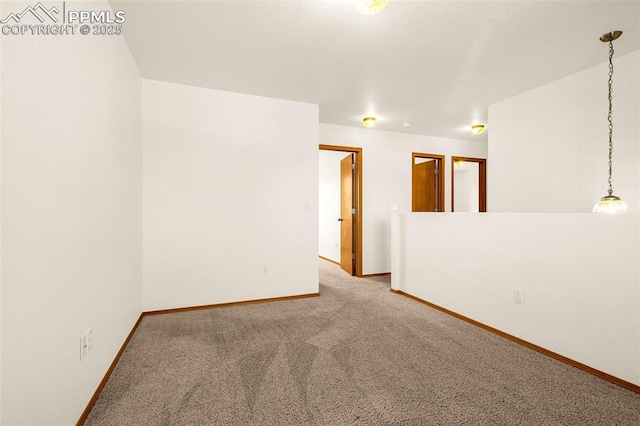 carpeted spare room featuring baseboards