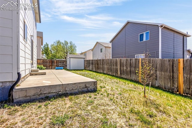 view of yard featuring a patio area, a shed, and an outbuilding
