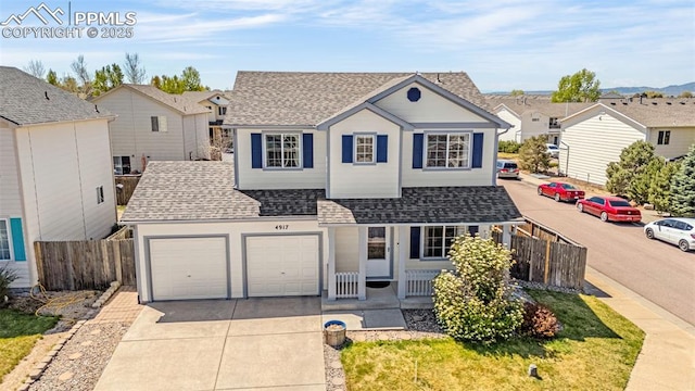 traditional-style home featuring roof with shingles, a porch, driveway, fence, and a garage