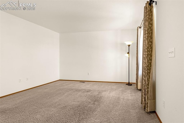 carpeted empty room with baseboards