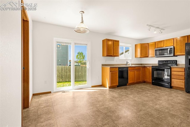 kitchen featuring black appliances, light countertops, brown cabinetry, and hanging light fixtures