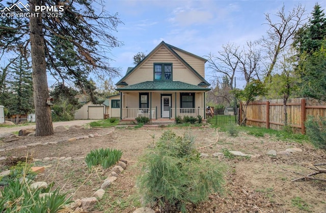 view of front of property with an outbuilding, fence, a shingled roof, a porch, and a detached garage