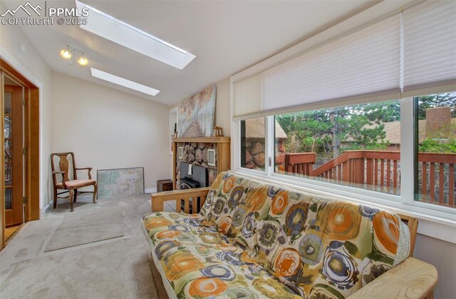 living room featuring plenty of natural light, baseboards, lofted ceiling with skylight, and carpet floors