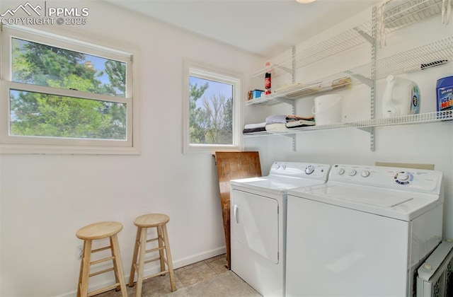 laundry room featuring washing machine and clothes dryer, baseboards, and laundry area