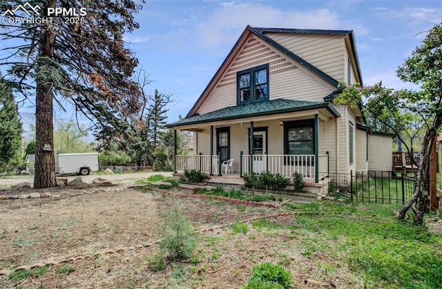 bungalow featuring covered porch and fence