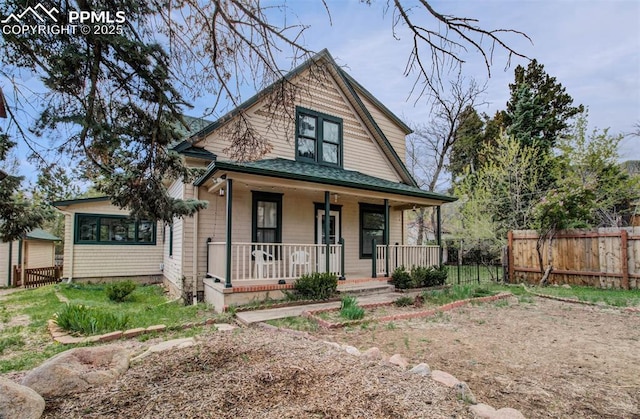 view of front of house with a porch and fence