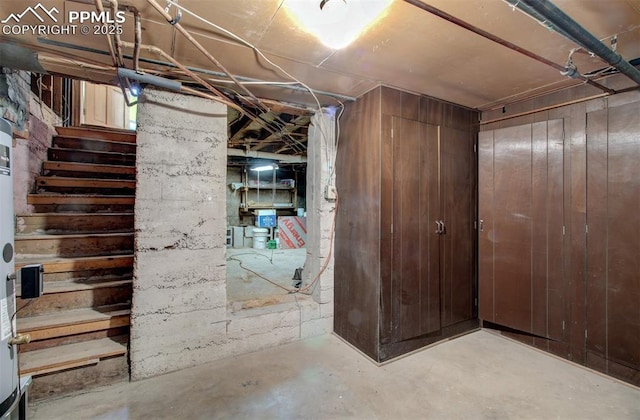 unfinished below grade area with stairs and wooden walls
