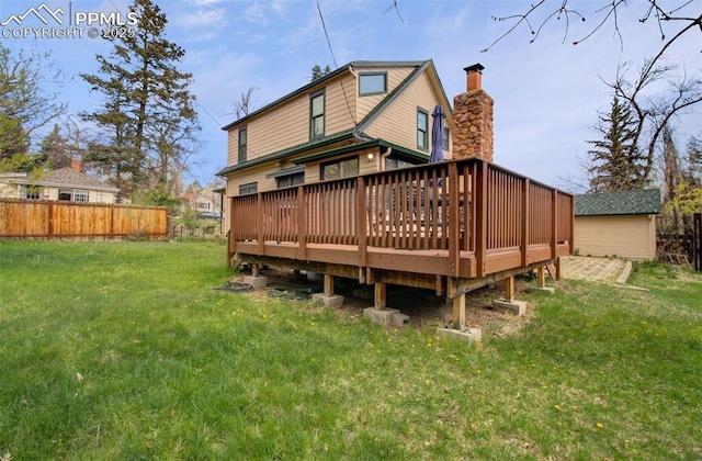 rear view of house with a yard, fence, and a wooden deck