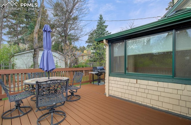 deck featuring outdoor dining space and grilling area