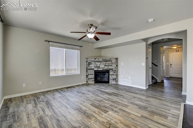 unfurnished living room with a ceiling fan, baseboards, and wood finished floors