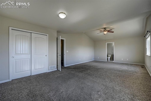 unfurnished bedroom featuring a closet, baseboards, visible vents, vaulted ceiling, and carpet floors