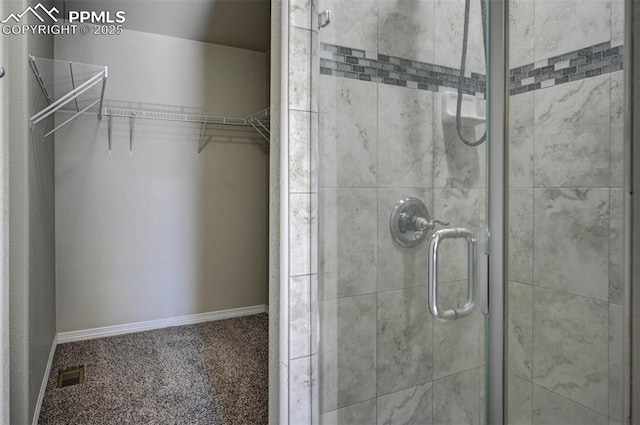 bathroom with visible vents, a shower stall, and a spacious closet