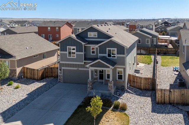 view of front of house featuring board and batten siding, an attached garage, a residential view, concrete driveway, and stone siding