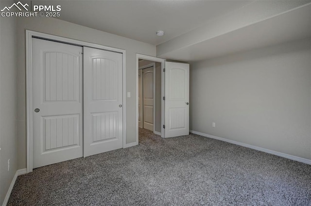 unfurnished bedroom with carpet, a closet, and baseboards