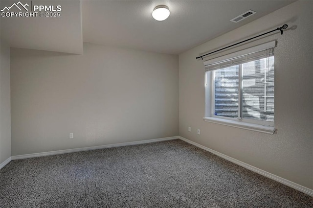 spare room with carpet, baseboards, and visible vents
