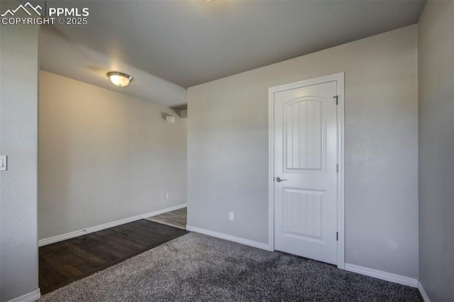 unfurnished room with baseboards and carpet