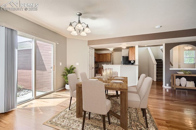 7601 Menagerie Ln, Colorado Springs, CO 80923 - dining space with a chandelier, light wood-type flooring, stairs, and baseboards