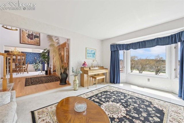 carpeted living room featuring a chandelier