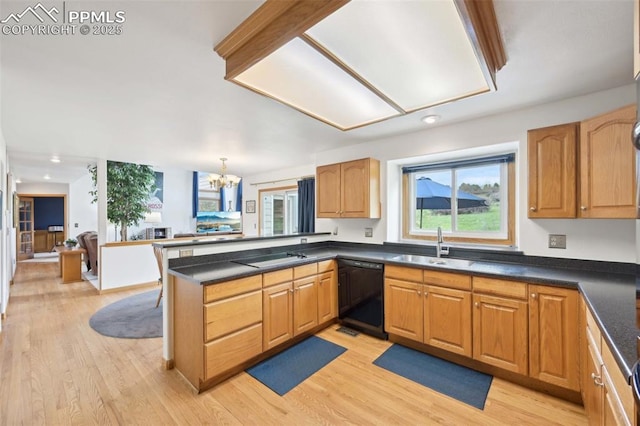 kitchen featuring black appliances, a peninsula, dark countertops, a chandelier, and light wood-style floors