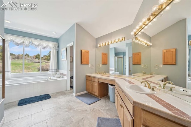 bathroom with vanity, lofted ceiling, a bath, a shower stall, and baseboards