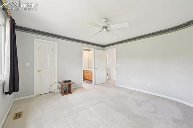 unfurnished bedroom with light carpet, baseboards, and connected bathroom