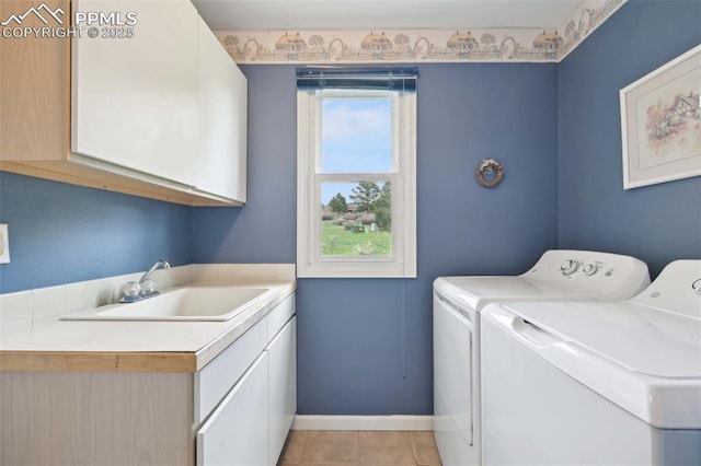 washroom with cabinet space, independent washer and dryer, baseboards, and light tile patterned floors