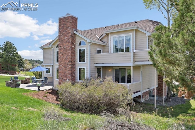 view of front of property featuring a chimney, a patio area, and a front yard