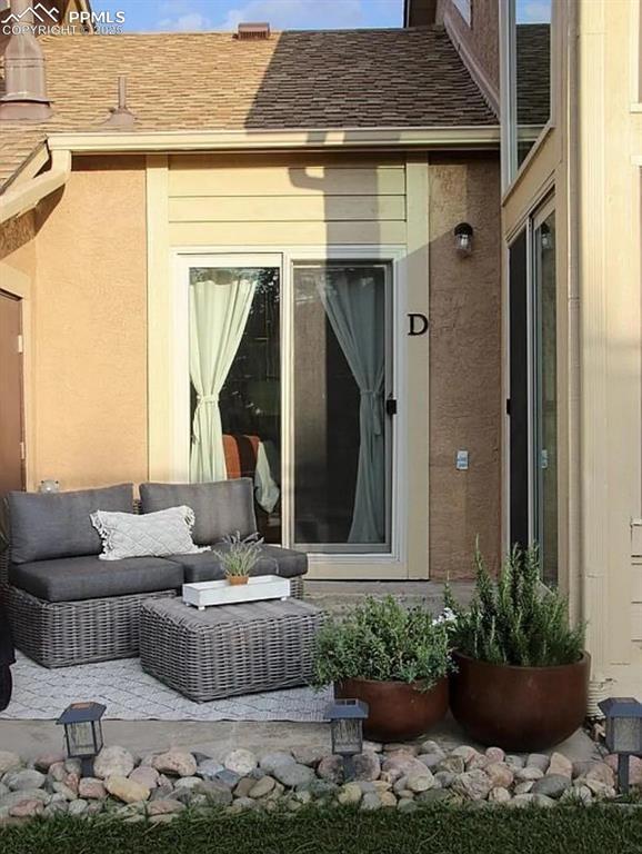 4070 Autumn Heights Dr Unit D, Colorado Springs, CO 80906 - exterior space featuring stucco siding, a shingled roof, and outdoor lounge area