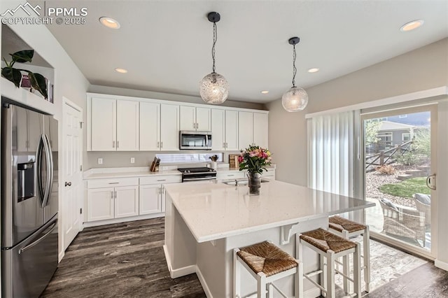 5905 Longford Way, Colorado Springs, CO 80927 - kitchen featuring white cabinetry, a kitchen island, stainless steel appliances, and a kitchen bar