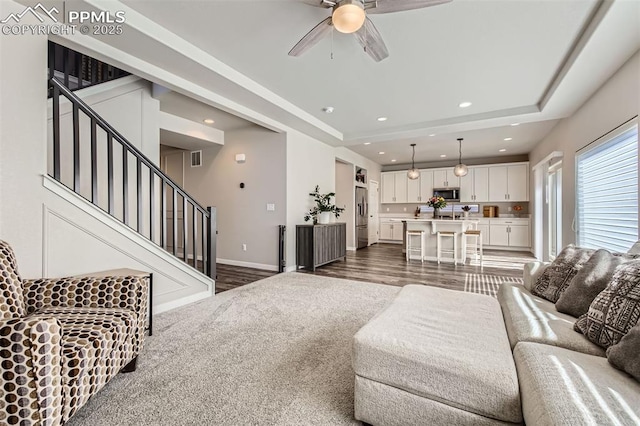 5905 Longford Way, Colorado Springs, CO 80927 - living room with recessed lighting, stairway, dark wood-style floors, a ceiling fan, and a tray ceiling