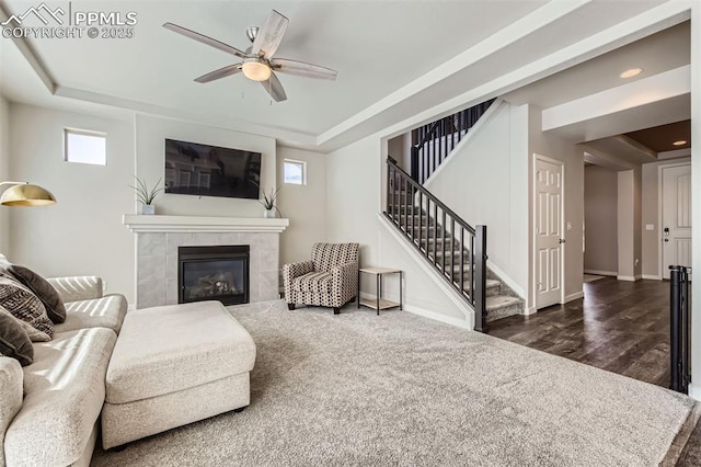 5905 Longford Way, Colorado Springs, CO 80927 - living room featuring stairway, a ceiling fan, a raised ceiling, baseboards, and a tile fireplace