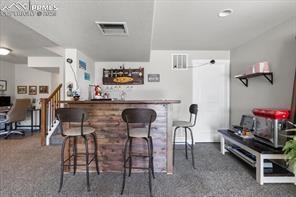 10150 Bracknell Pl, Peyton, CO 80831 - indoor dry bar with carpet and stairway