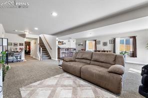 10150 Bracknell Pl, Peyton, CO 80831 - living room featuring stairs, recessed lighting, and carpet
