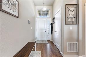 10150 Bracknell Pl, Peyton, CO 80831 - doorway featuring dark wood finished floors and baseboards