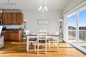10150 Bracknell Pl, Peyton, CO 80831 - dining room with plenty of natural light, wood finished floors, and a chandelier